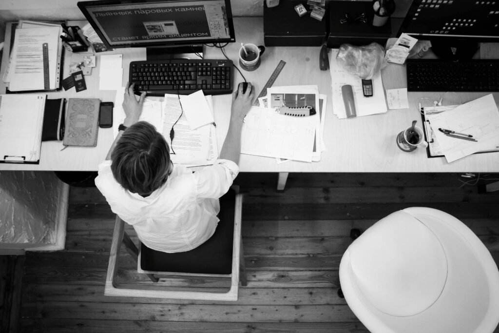 Vista superior de hombre trabajando con computadora en blanco y negro